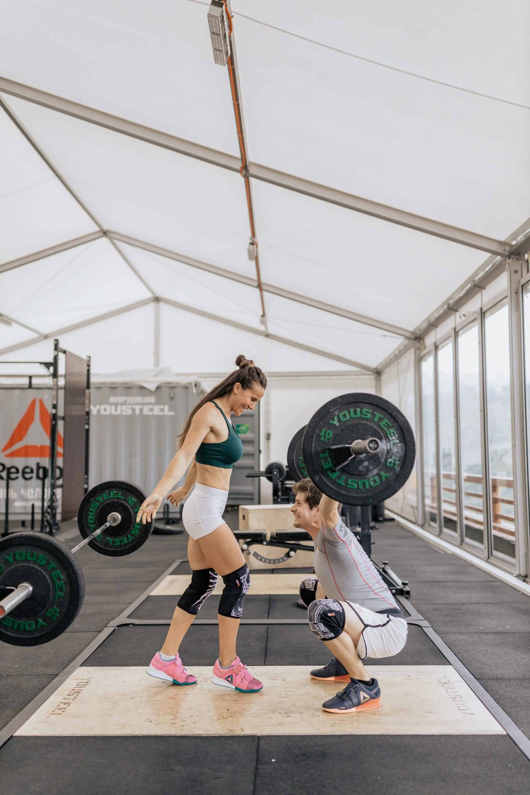 Dos deportistas entrenando halterofilia en un gimnasio